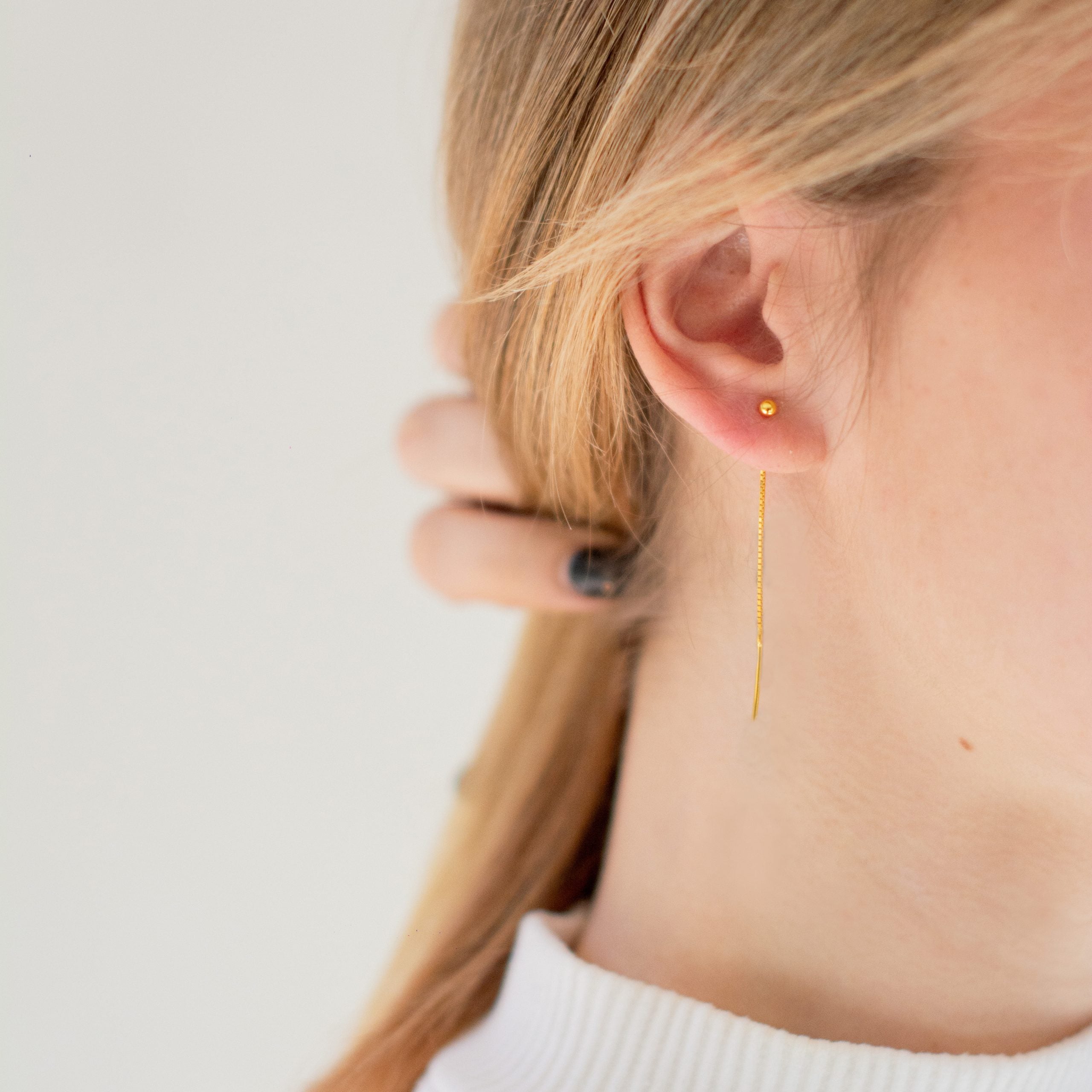 Złocone kolczyki z kulką przeciągane przez ucho