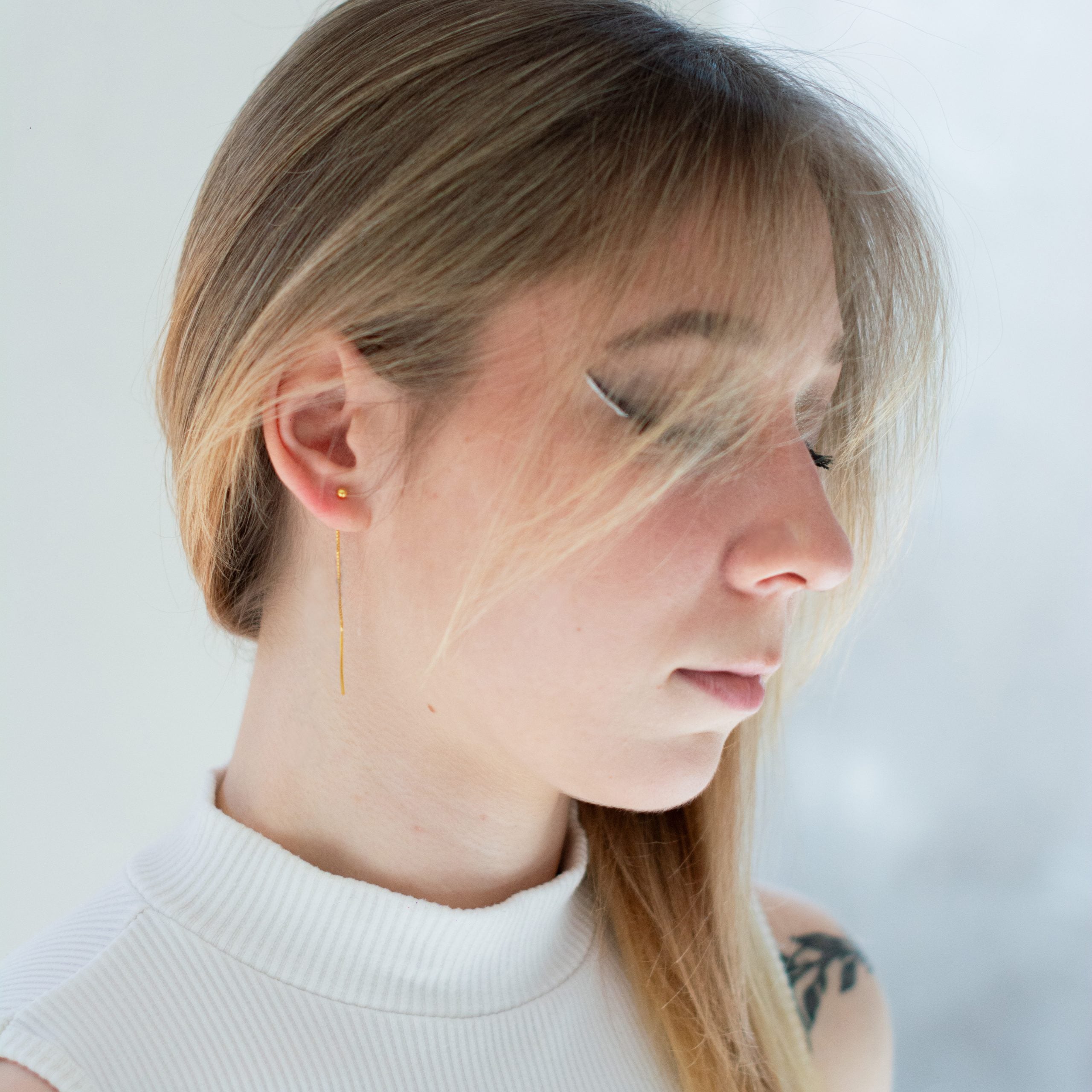 Złocone kolczyki z kulką przeciągane przez ucho